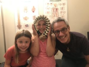 man with kids in front of anatomy charts